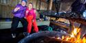 children enjoy sausages at the bonfire place by the skating rink in Skien leisure park