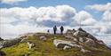 two walkers with a dog on top of mount Skorve