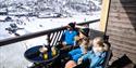 family sitting on the balcony of an apartment at Haukelifjell ski center