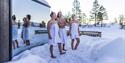 3 young people in the snow in front of the Panorama sauna