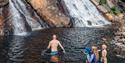 A family with children swims at Egderudfossen in Hjartdal.