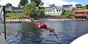 Boy that plunges from the pier at Toke, at the bathing place at Toke Brygge in Drangedal