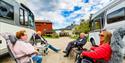 2 couples sitting in front of their motorhomes at Hulfjell family park