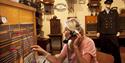 lady sitting in an old telephone exchange that is exhibited at the Z-museum in Nissedal