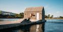 boy jumps from diving board in front of the floating sauna in Langesund