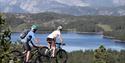 sykling over svaberg på Gautefallheia i Drangedal, pause på toppen med utsikt over vannet og store fjelle i bakgrunnen