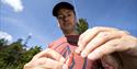 man putting hook on fishing rod