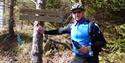 cyclist stands by signs for horse mountain