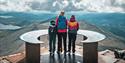 lady and 2 children stand on top of Mount Gausta