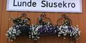 sign for Lunde Slusekro with flowers underneath