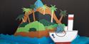 Pop up papirteater. På bilde en øy med palmer og en båt med en elefant oppi.