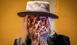 Tim Ledfoot Scott McConnell med tatoveringer, svartmalte negler og hatt
