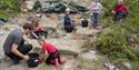 Barn graver i den arkeologiske sandkassen på Vest-Telemark Museum Eidsborg