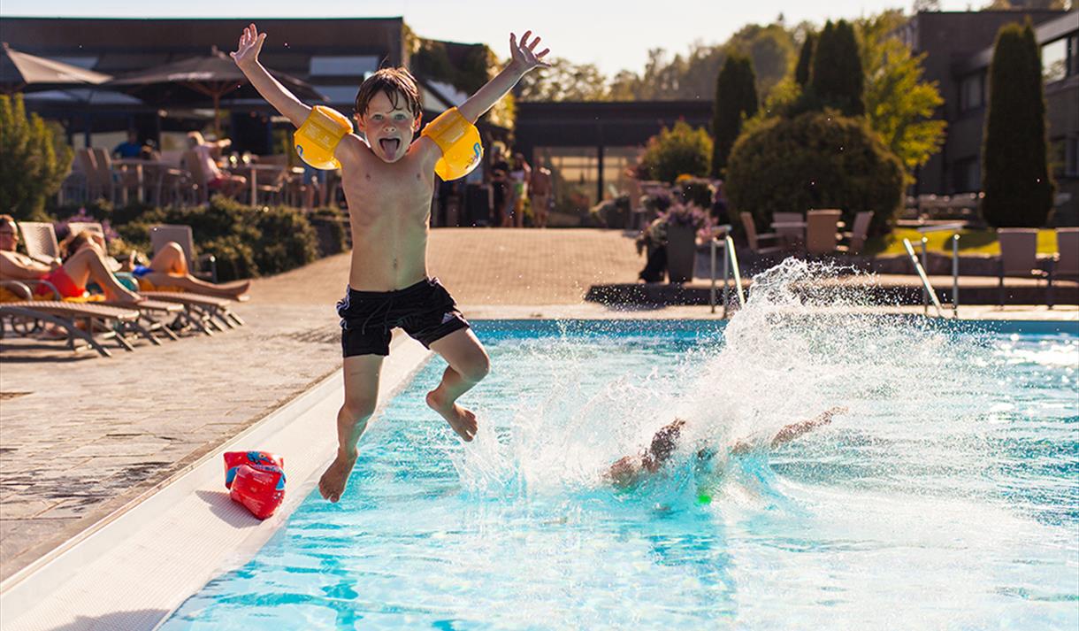 little boy jumps in swimming pool at Bø Hotel