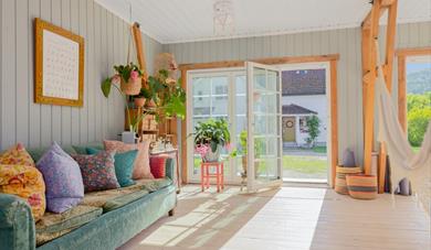 bright and pleasant living room with access to the garden in a rental house at Yogagården