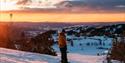 gutt på snowboard på toppen av alpinbakken på Lifjell skisenter i solnedgang