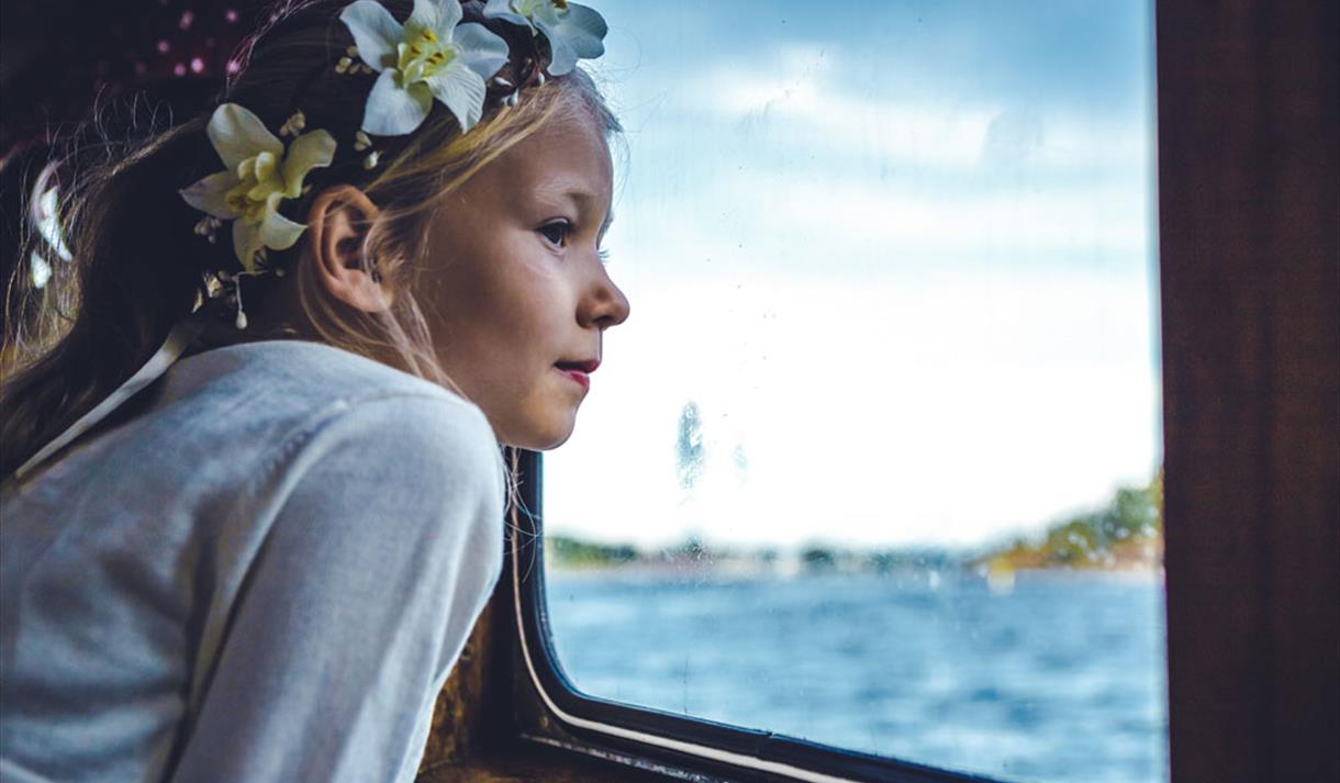 girl looks out of the window on the boat