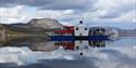 Fjonefergen med 2 biler og flere mennesker ombord trafikkerer over innsjøen Nisser i Telemark