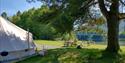 guests enjoy themselves on the lawn by the water at Lystang Glamping in Notodden