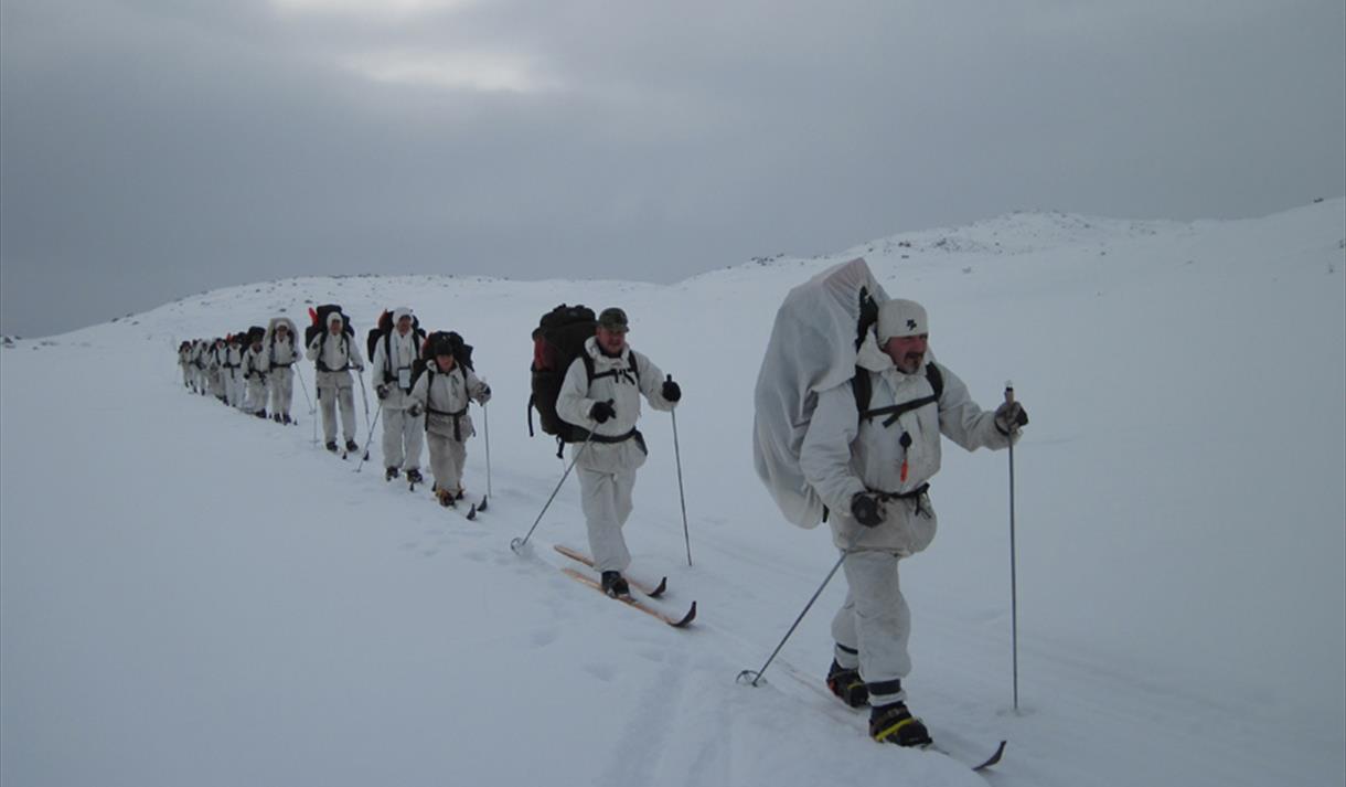 gruppe av menn på ski kledd i hvit