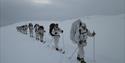 gruppe av menn på ski kledd i hvit