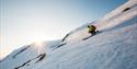 Mann kjører Telemark ned bakken på Haukelifjell skisenter