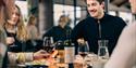 gjester som koser seg med mat og vin på restaurant Blikk Raw & Grill på Gaustablikk fjellresort