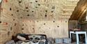 climbing wall and seating area in the barn at Yogalåva glamping