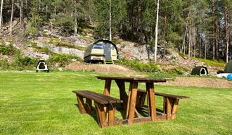 Pod cabin with seating and dining area in front of Hulfjell