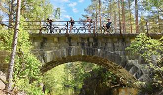 group of cyclists cycle over a bridge on the cycle path "old Treungenbanen"