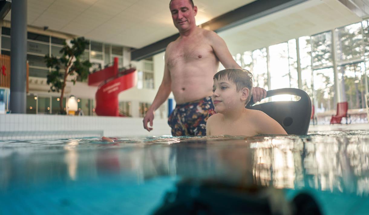 father and son in a wheelchair in the swimming pool in Skien leisure park