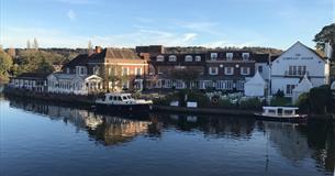 View of Macdonald Compleat Angler from river with boats moored.