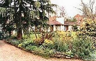 Colonial type house in half-acre garden surrounded by trees