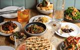 A table full of Mediterranean and Middle Eastern food with drinks.