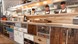 Three chefs behind a the kitchen bar that features lots of drawers.