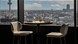 Two high chairs sitting with a circular table looking out over the city region.