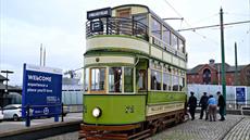 A vintage green tram attached to the original tramlines outside of the museum.