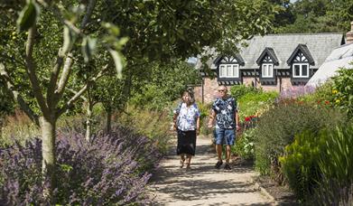 A couple walking through a garden area at National Trust Quarry Bank