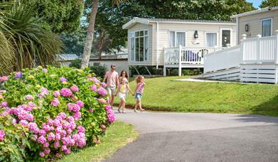 Family walking past the lodges at John Fowler Holiday Parks