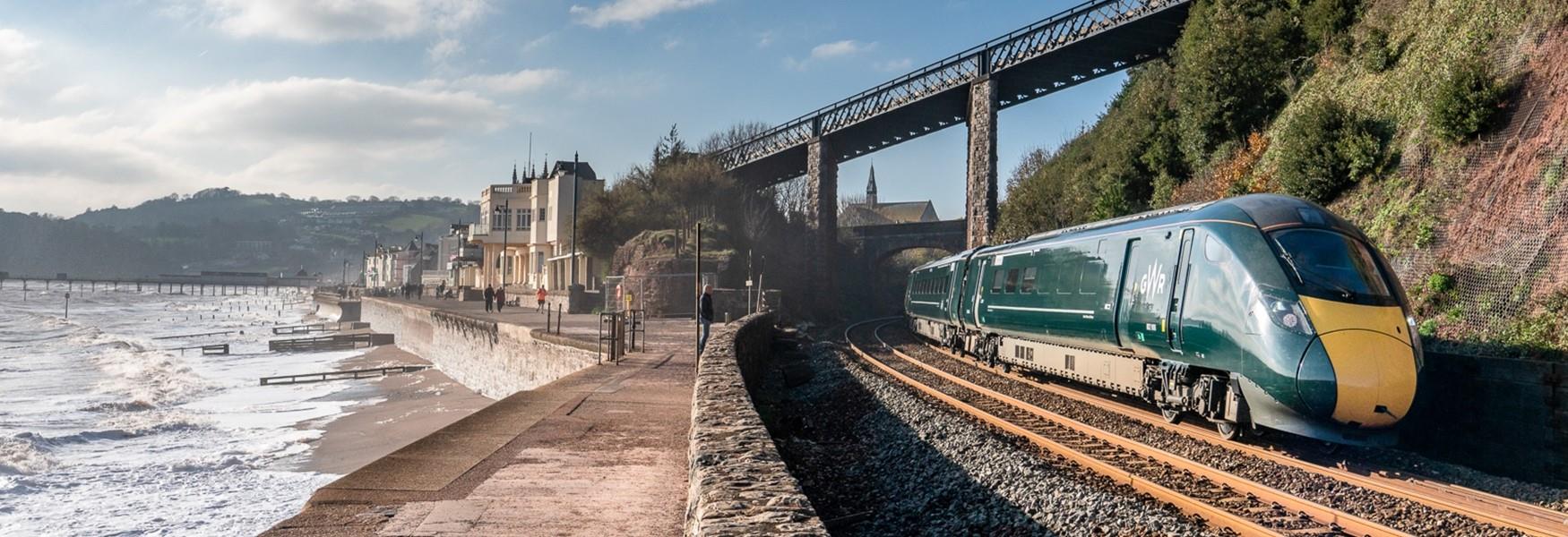 GWR train travelling alongside a coastal town