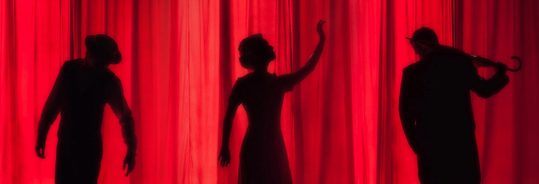 theatre performers against curtain