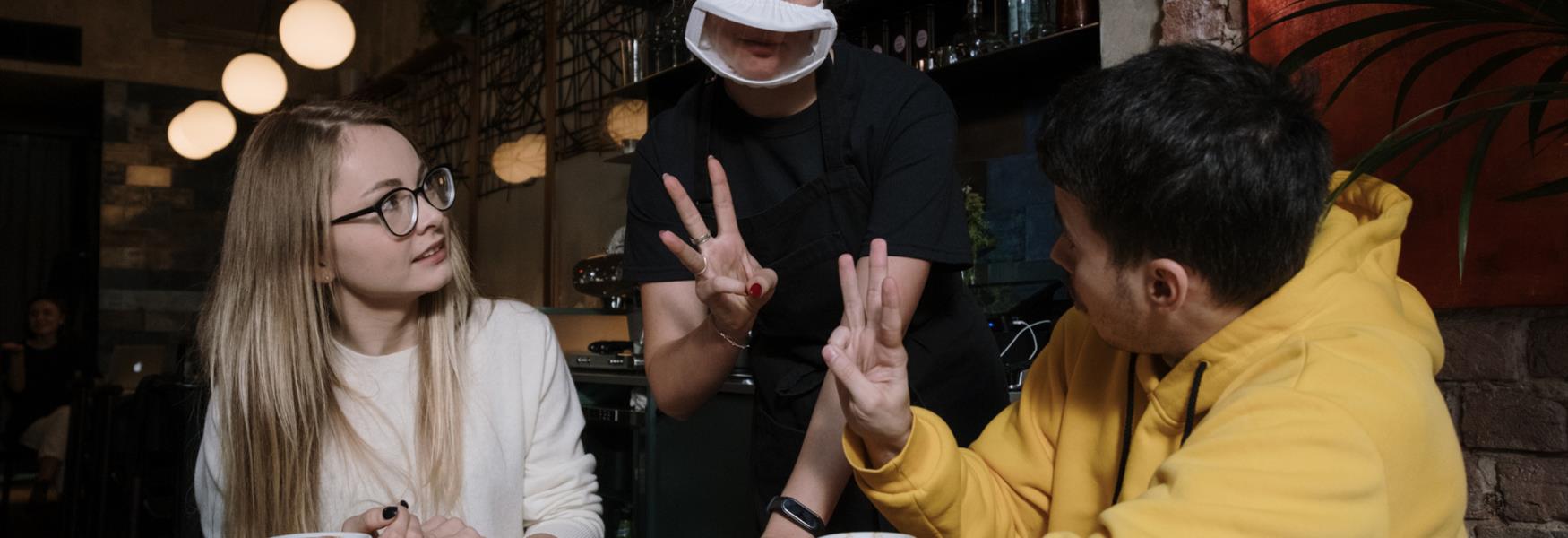 People ordering in a cafe in sign language