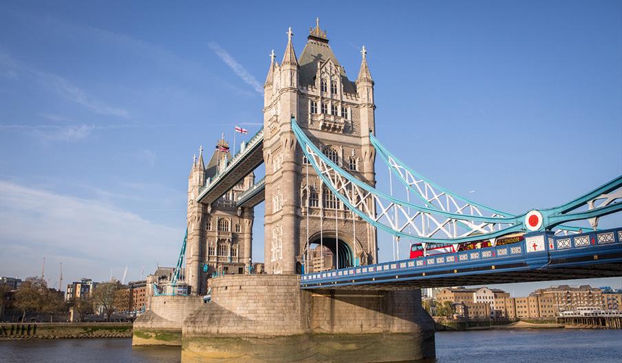 A red bus driving over Tower Bridge