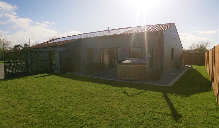 Outside Mountain Lodge showing the lawn and the hot tub