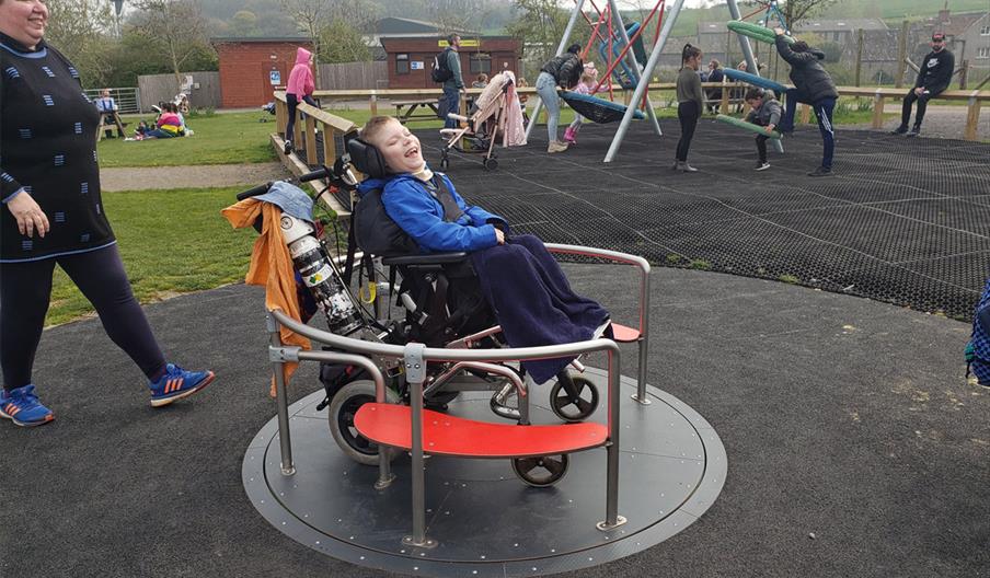 A child in a wheelchair in the wheelchair friendly play area  at Noah's Ark Zoo Farm