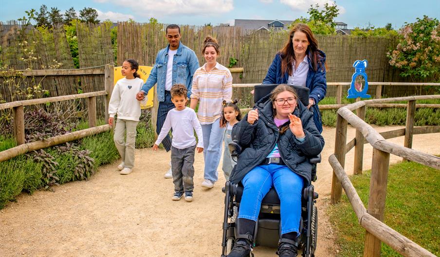 A group of people following the path at Fairytale Farm, with one girl in a wheelchair in front