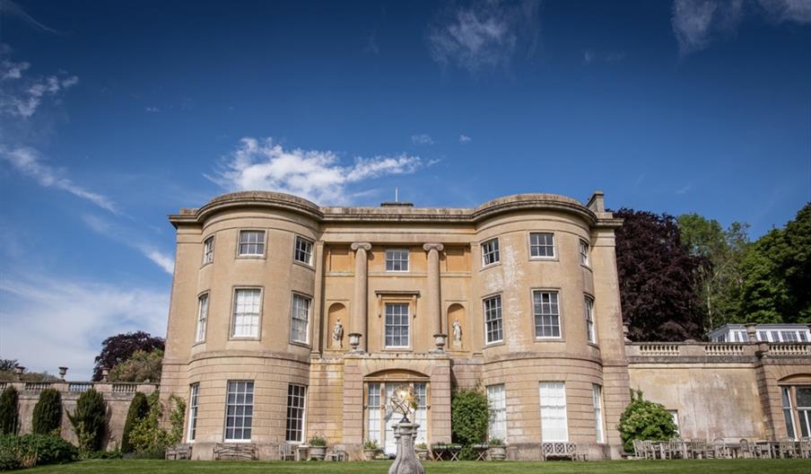 A large Bath stone building in beautiful gardens at American Museum and Gardens