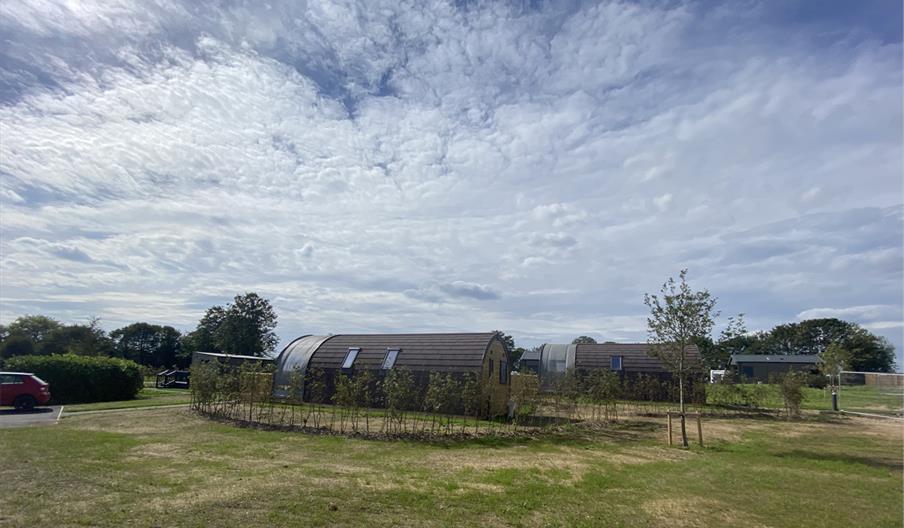 Some of the pods at Experience Freedom Glamping at Cayton Village with the surrounding countryside