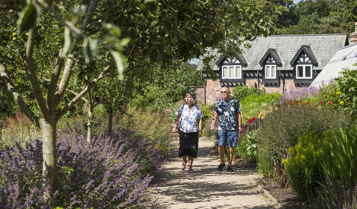 A couple walking through a garden area at National Trust Quarry Bank
