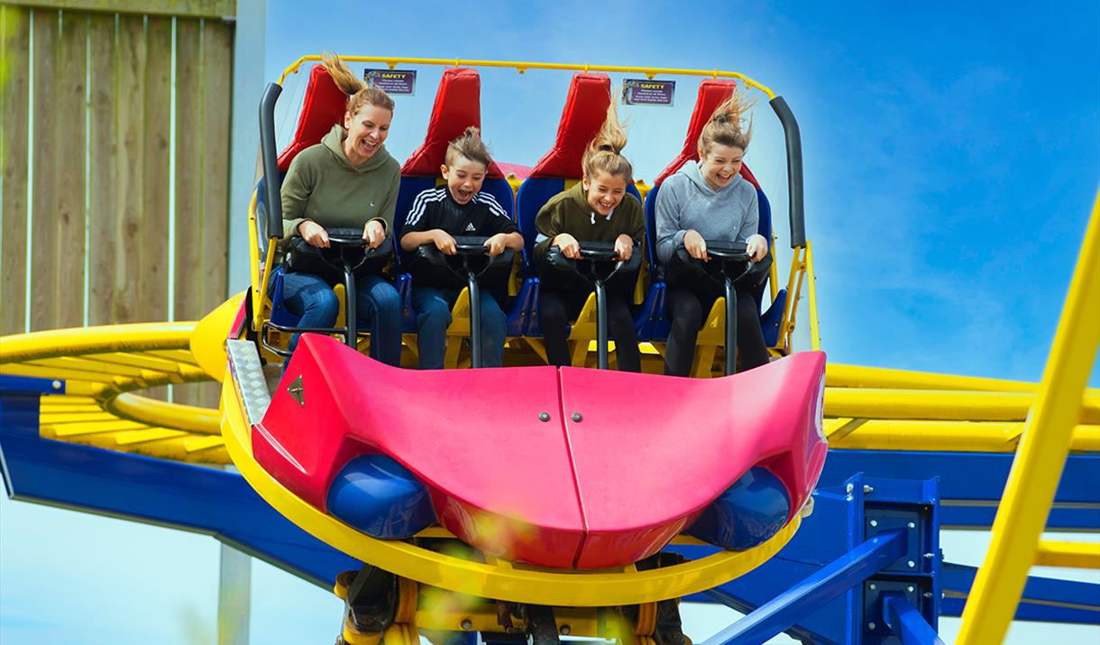A photo of a family having fun on a Rollercoaster that twists and spins.
